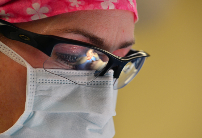 Photo en gros plan d'une femme chirurgien portant un masque